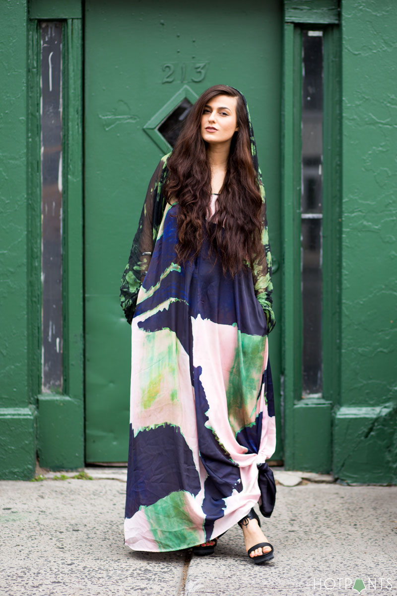 Teen girl standing on a bridge side footpath. Holding up her trendy maxi  dress outfit. Stylish