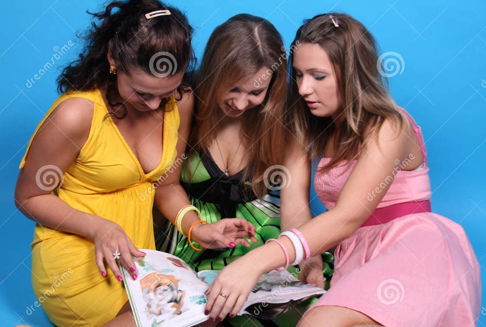 girls-having-fun-reading-glossy-magazine-7549647